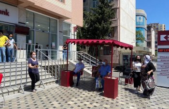Kapital Bank filialların önündə müştəriləri günvurmadan qoruyur  